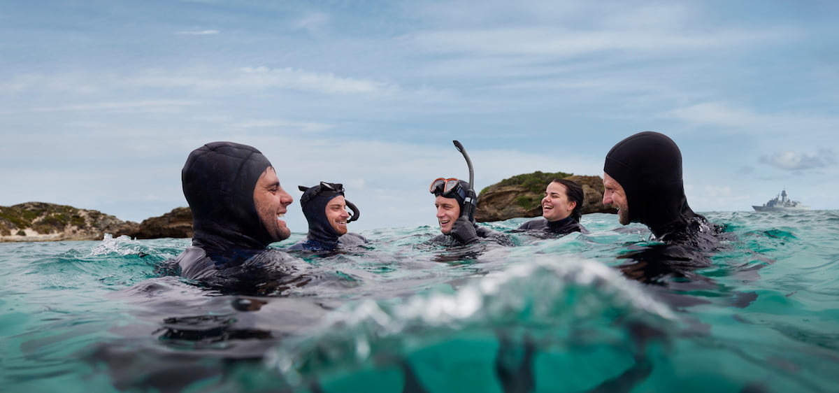 A group of Navy members swimming in snorkling gear.