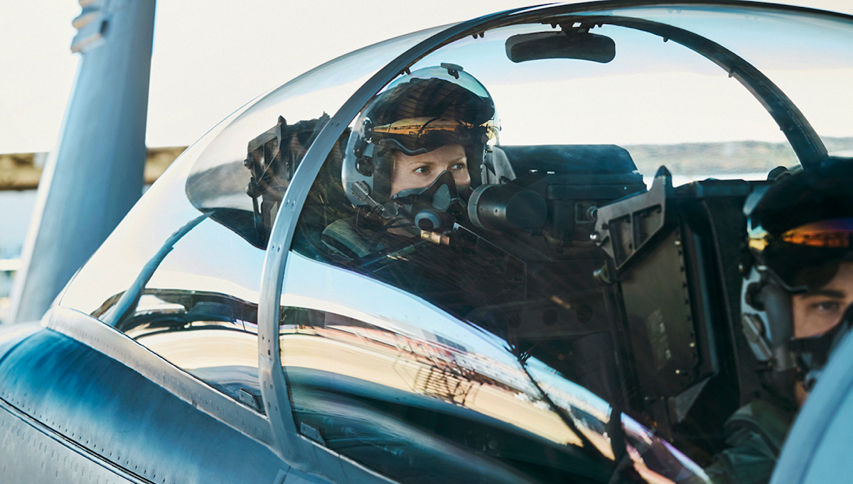 Looking into the cockpit, we see a female pilot preparing for take off.