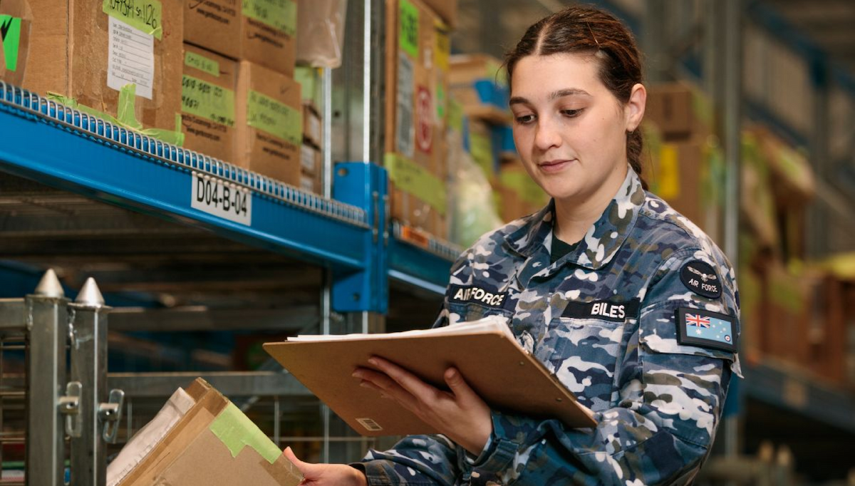 A women in Air Force uniform checks the stock in the warehouse.