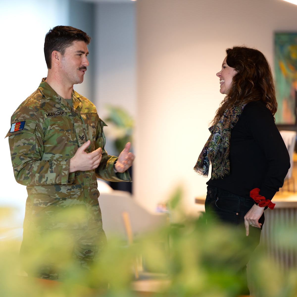 A man in uniform speaks to a woman.